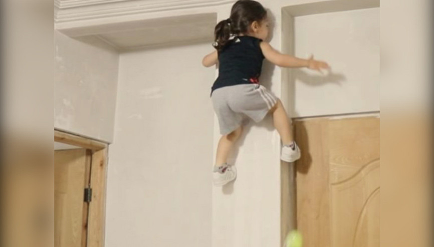 Düz duvara tırmanan örümcek çocuk