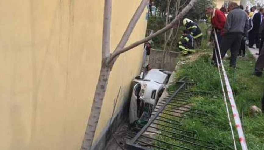 Otomobil ev ile bahçe duvarı arasına yan yatarak devrildi