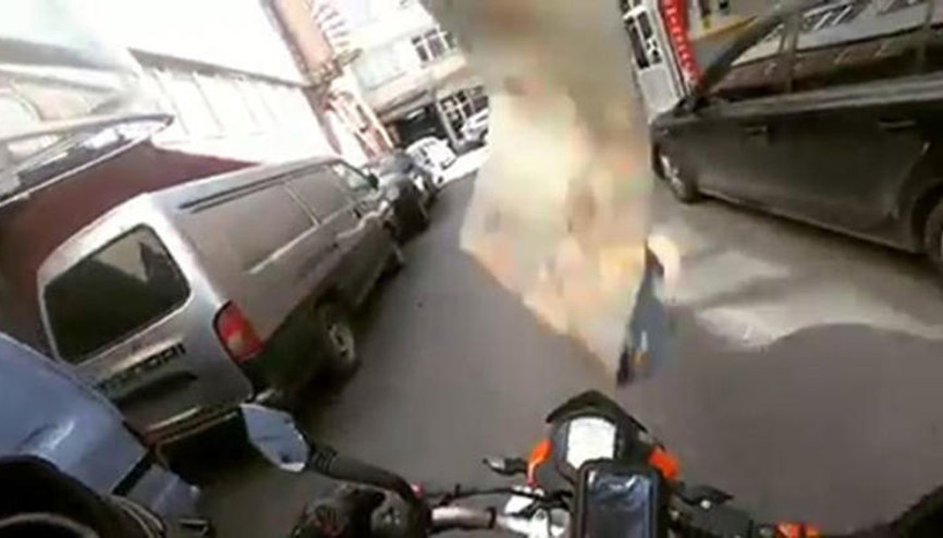 Seyir halindeki motosikletlinin başına halı düştü