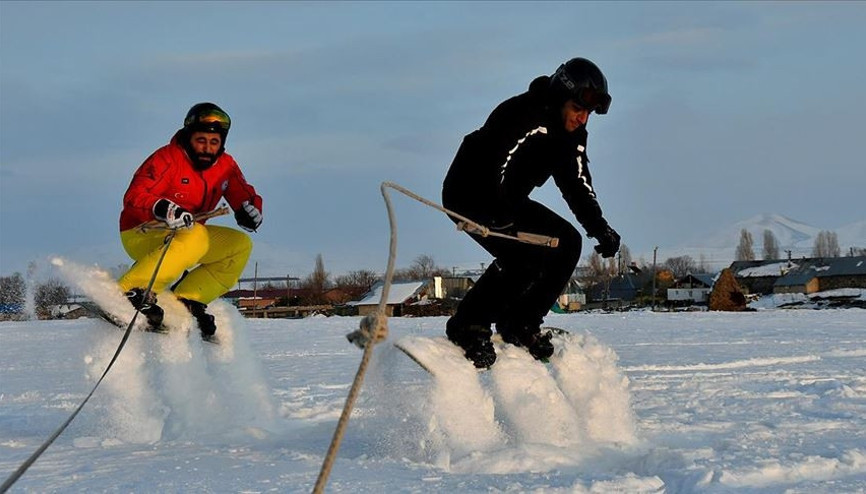 Arazi aracıyla karda snowboard yaptılar
