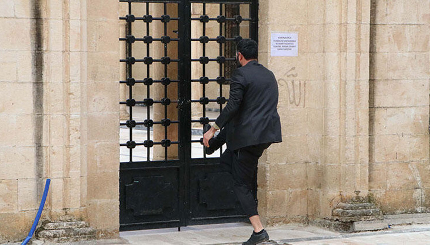 Caminin kilitli kapısını zorlayan cemaati polis engelledi