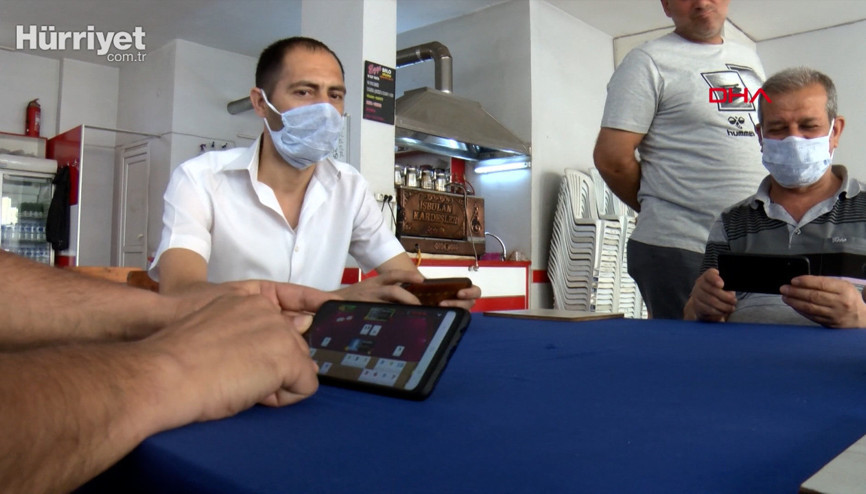 Koronavirüs yüzünden kahvehanede cep telefonuyla okey oynadılar