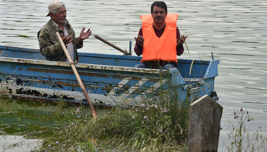 Su altında kalan mezarlığa sandalla gidip, dua ediyorlar