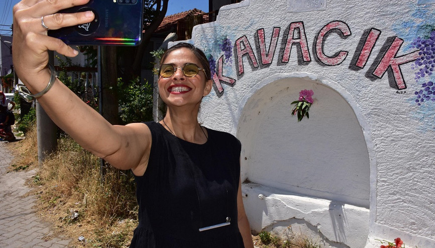 Tuval olan köy duvarları önünde hatıra fotoğrafı çektiriyorlar