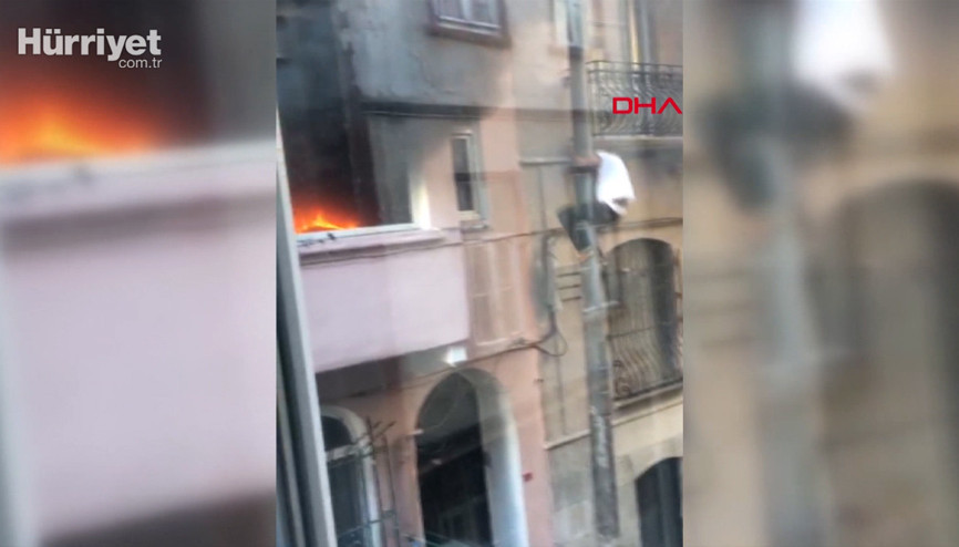 Çıkan yangında aydınlatma direğinden kayarak kaçtı