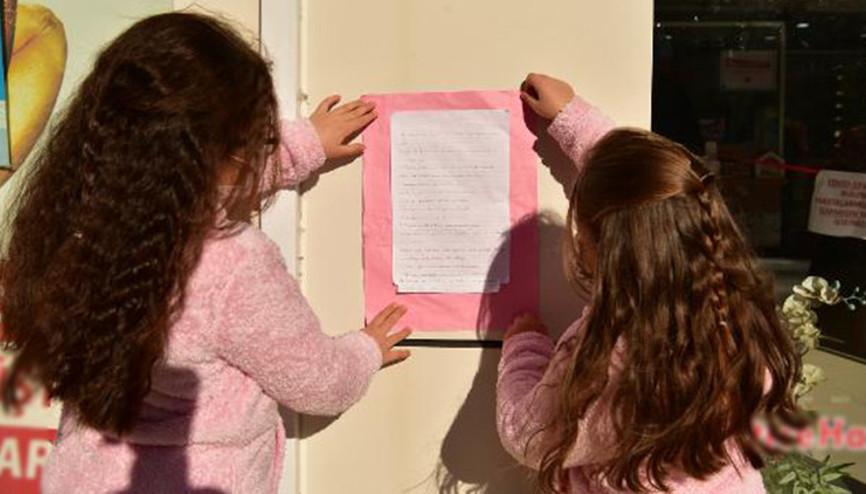 İki kardeş okula gidebilmek için sokaklara koronavirüs bilgi afişleri asıyor