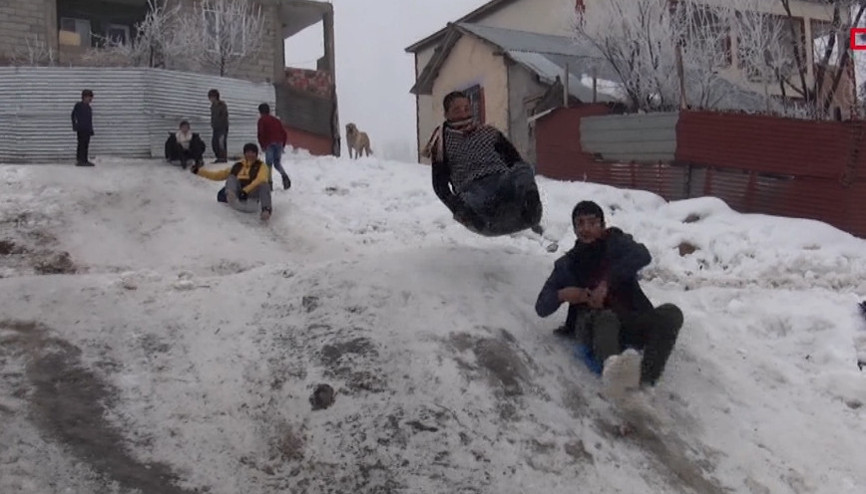 Çocuklar karın keyfini poşet ve plastik bidonlarla kayarak çıkarıyorlar