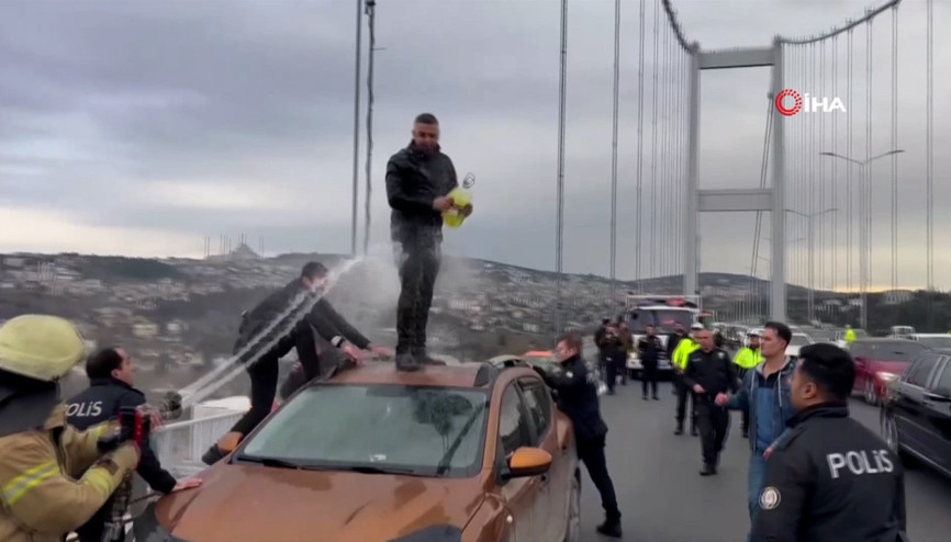Polisin ikna edemediği şahsı itfaiyeci su sıkarak aracın üzerinden indirdi
