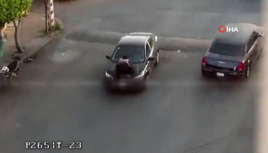 Aracının kaputundaki kadına aldırış etmenden yoluna devam etti