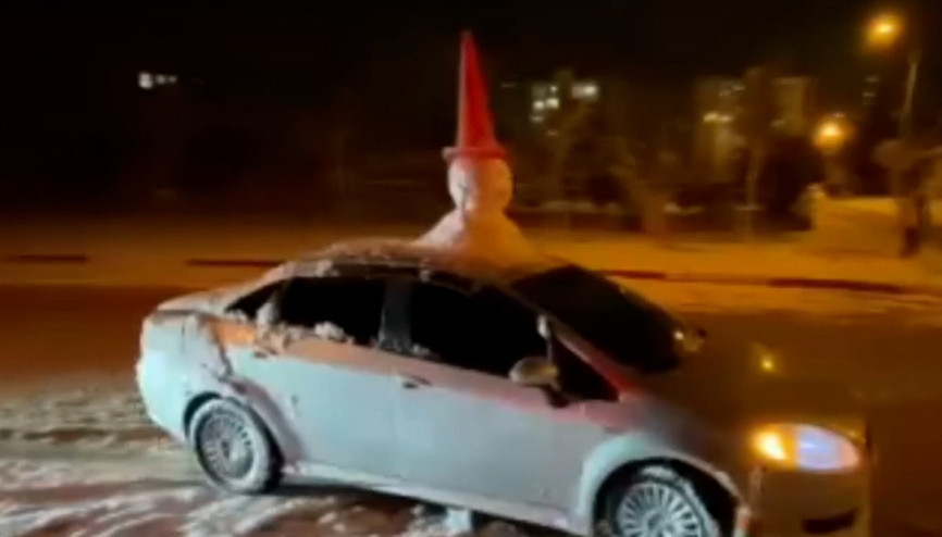 Otomobilinin tavanına yaptığı ‘kardan adam’ ile şehir turu attı