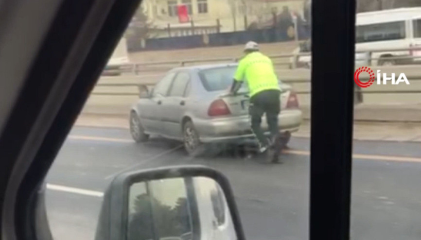 Trafik polisi arızalanan aracı ittirerek yol kenarına çekilmesini sağladı