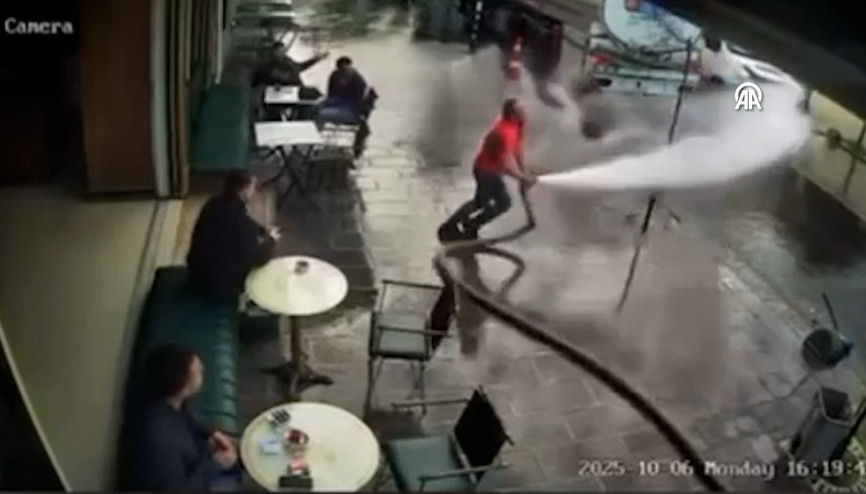 Bir kişinin tazyikli suyla çevredekileri ıslatması kamerada