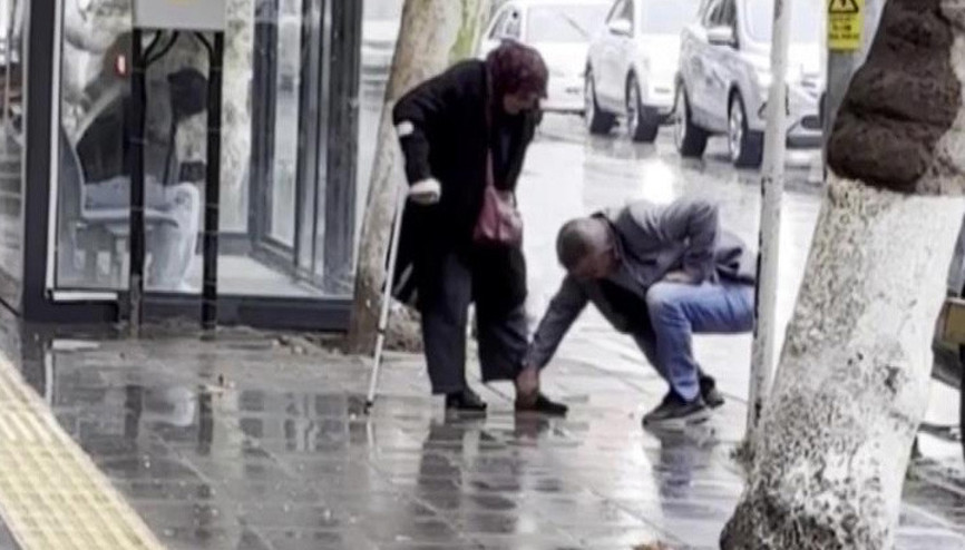 Bankaya çamurlu girmesin diye annesinin ayakkabısını elleriyle temizledi