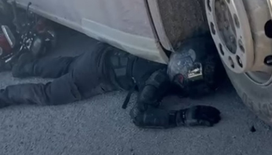 Korkutan görüntü: TIRın altında sıkıştı Kaskı ve koruyucu kıyafetleri sayesinde kurtuldu... Korkmuyorum, siz de korkmayın